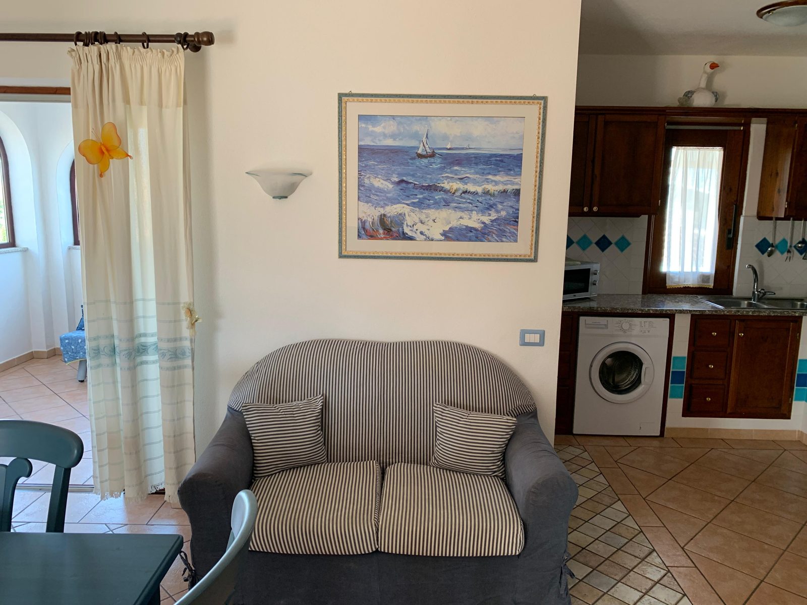 Living room with sofa and washing machine corner at Terrazza sul Mare — vacation rental in San Teodoro, Sardinia