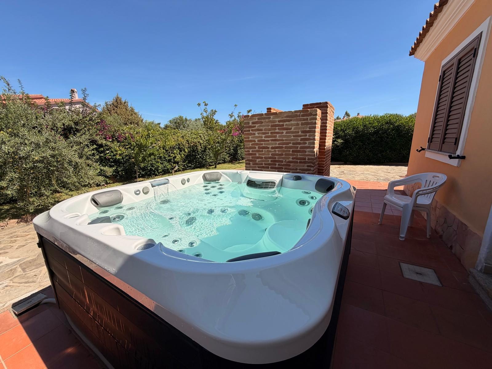 Jacuzzi surrounded by garden and hedges at Casa del Sole — vacation rental in San Teodoro, Sardinia