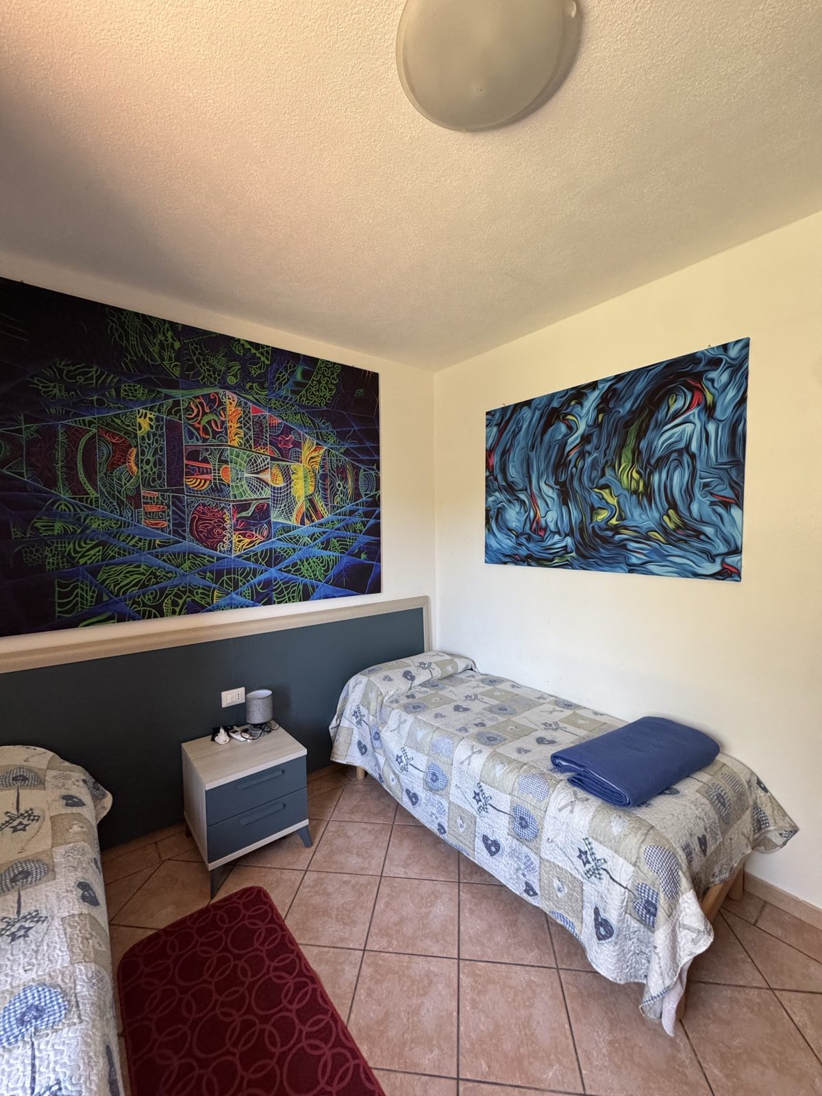 Single bedroom with colourful paintings at Oasi del Mare — vacation rental in San Teodoro, Sardinia