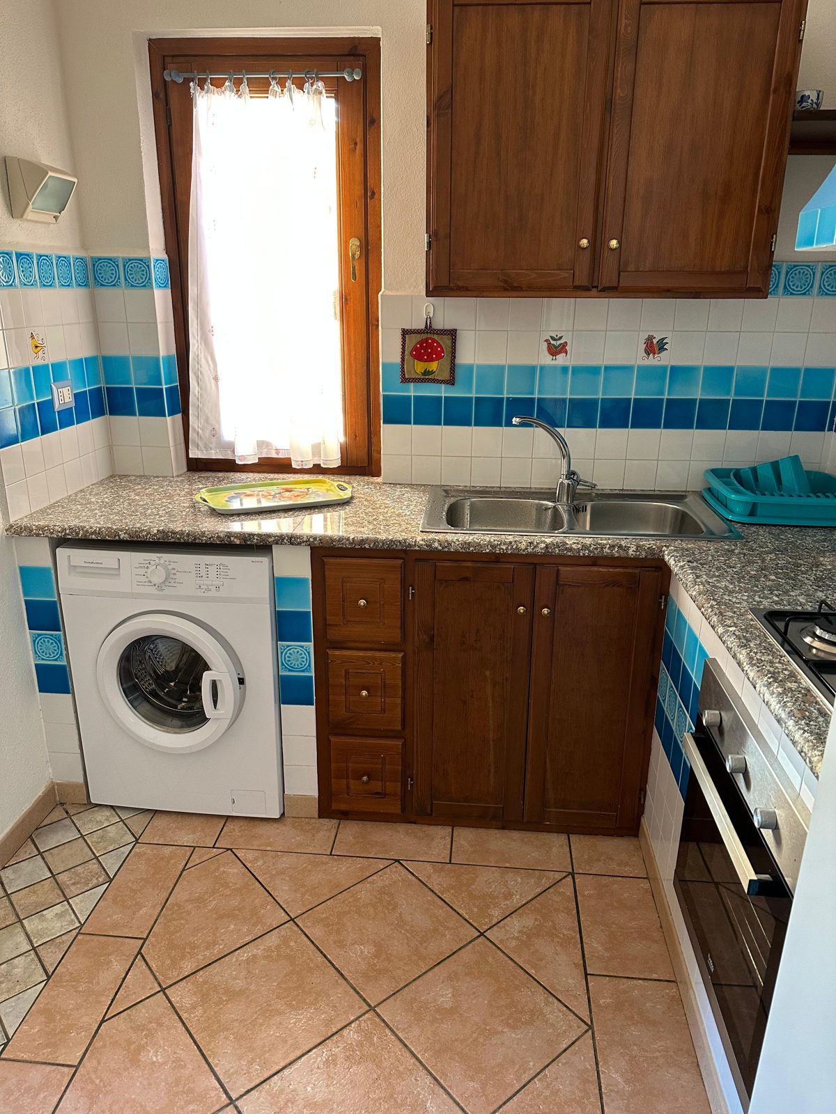 Equipped kitchen with oven and washing machine at Casa del Sole — vacation rental in San Teodoro, Sardinia